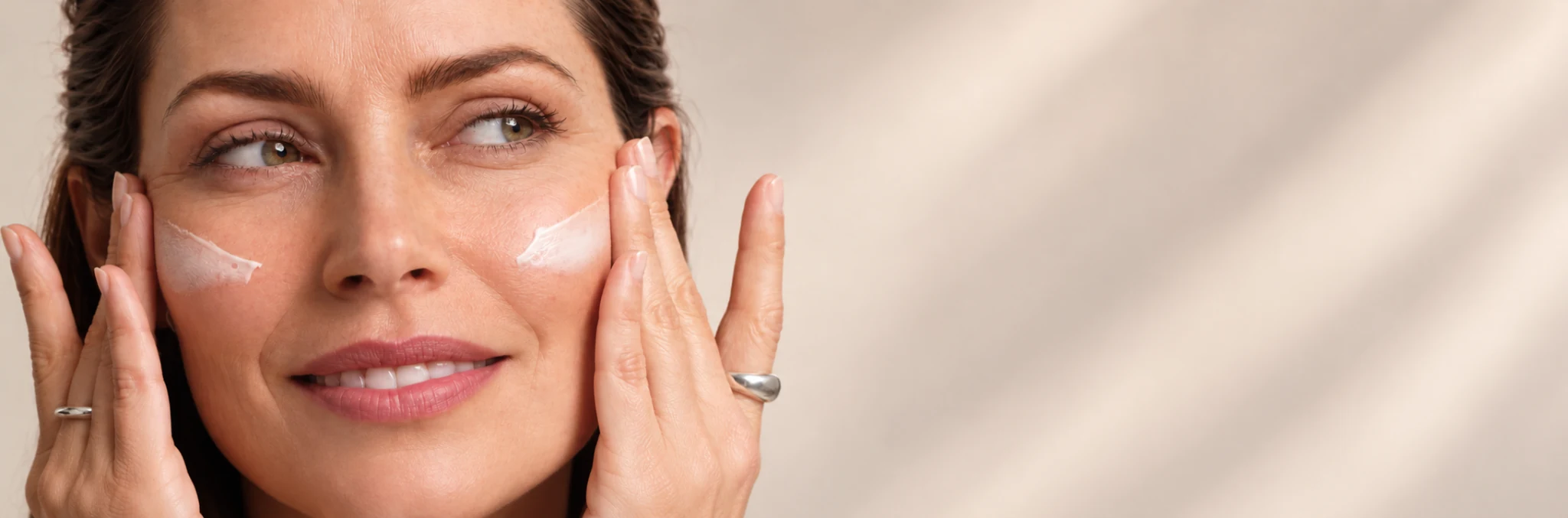 Donna che applica la crema sulle guance con entrambe le mani