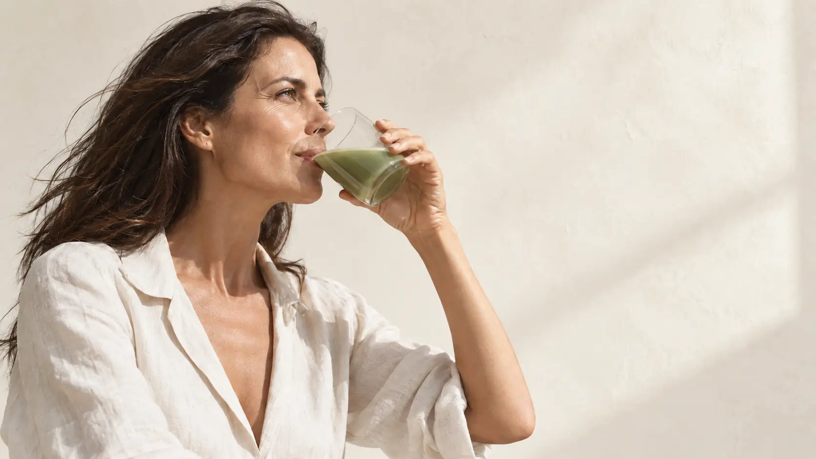 Donna che assume una bevanda verde CollaVéa